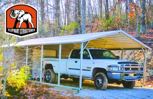 Metal carport used as a truck cover with utility shed and roll up garage door.
