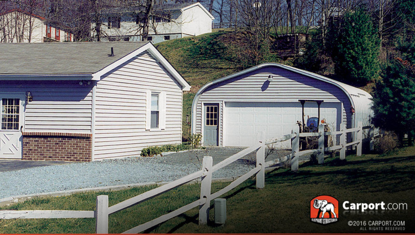 A model steel arch garage with one wide roll up door and a walk in door with grid windows.