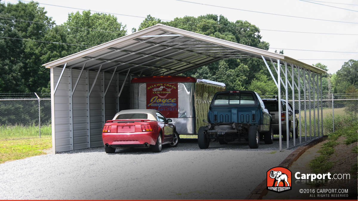 Four car carport with one side enclosed to protect from the elements.